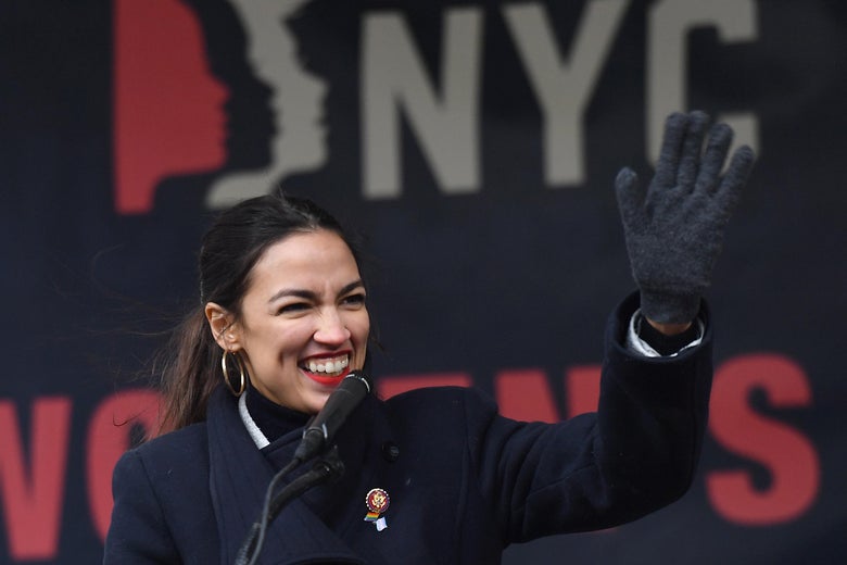 Alexandria Ocasio-Cortez, smiling and waving.